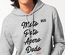 a person wearing a grey hoodie that says moto poto apero dodo