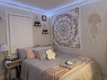 a bedroom with a tapestry hanging on the wall and a blanket on the bed