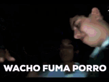 a man is holding a microphone and the words wacho fuma porro are visible