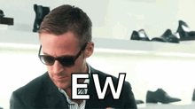 a man wearing sunglasses says ew in front of a shoe display