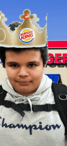 a boy wearing a burger king crown and a champion sweatshirt