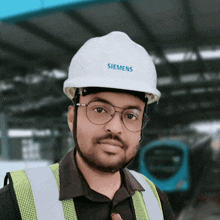 a man wearing a white siemens hard hat