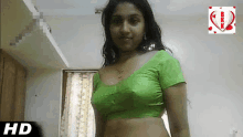 a woman in a green crop top is standing in a room .