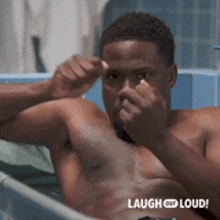 a shirtless man is laying in a bathtub with the words laugh loud on the bottom