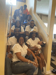 a group of people posing for a picture on a set of stairs including a woman holding a baby