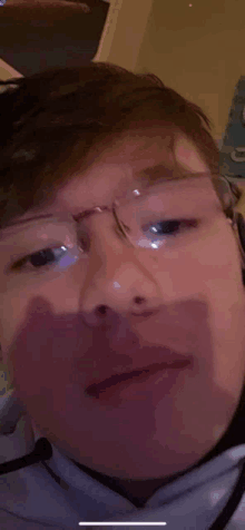 a close up of a young man wearing glasses and headphones .