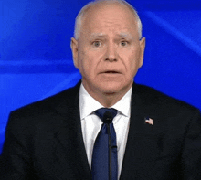 a man in a suit and tie is giving a speech .