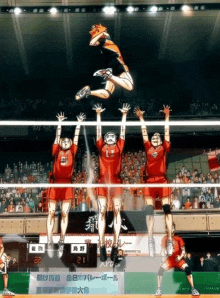 a group of volleyball players jumping in the air