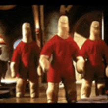 a group of dolls wearing red shirts are standing next to each other .