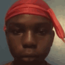 a man wearing a red headband looks at the camera