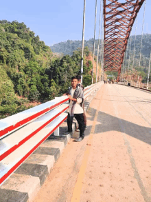 a man standing on a bridge with a backpack