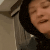 a close up of a person wearing a hoodie and smiling .