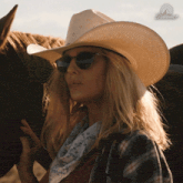 a woman wearing a cowboy hat and sunglasses stands next to a horse with a paramount logo in the background
