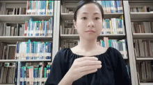 a woman stands in front of a bookshelf with a few books on it including one that says ' dictionary ' on it