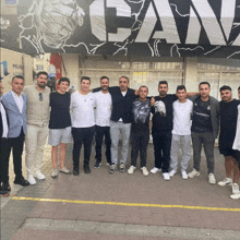 a group of men standing in front of a banner that says fan