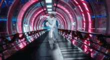 a person in a white costume is walking down a tunnel