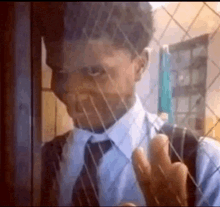 a man in a suit and tie is standing in front of a window .