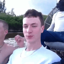 a man in a white shirt is sitting on a boat