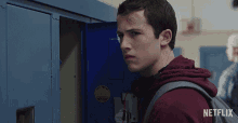 a young man with a bandage on his forehead is standing in front of a locker that says netflix on it