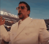 a man wearing sunglasses and a white suit says " levantate mijo "