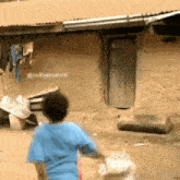 a boy in a blue shirt is standing in front of a brick building with the words @nolywoodroll written on the bottom