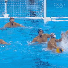 a group of men are playing water polo in a pool and one of them is wearing a hat that says ' star ' on it