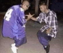 two men in plaid shirts and purple shirts are standing next to each other .