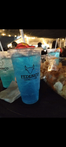 a blue drink in a plastic cup with federico written on it