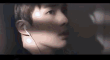 a close up of a man wearing ear buds in a dark room .