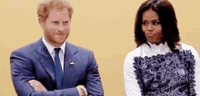 a man in a suit and tie and a woman in a white shirt are standing next to each other .