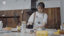 a woman in an apron is preparing food in a kitchen with a box that says twice tv on it