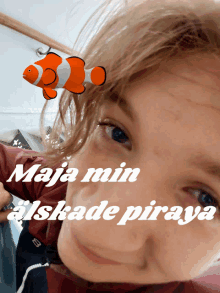 a girl with a clown fish on her head and the words maja min alskade piraya