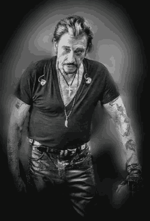 a black and white photo of a man with tattoos on his arms