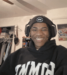 a young man wearing headphones and a black shirt that says tnmn