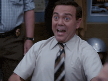 a man in a white shirt and tie has his mouth open