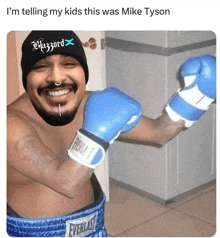 a shirtless man wearing blue everlast boxing gloves and a blizzard beanie