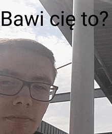 a man wearing glasses is standing in front of a sign that says " bawi cie to "