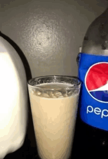 a bottle of pepsi sits next to a glass of milk