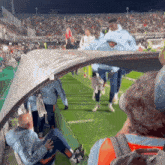 a group of people are walking on a soccer field and one of them is wearing a adidas jacket