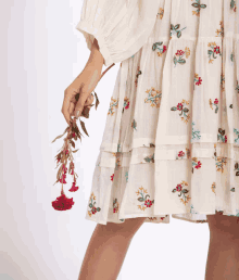 a woman in a white dress is holding a bouquet of flowers