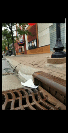 a manhole cover on the sidewalk with a piece of paper on it that says ' i 'm sorry '