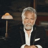 a man with a beard wearing a black suit and white shirt