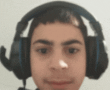 a young man wearing headphones and a microphone looks at the camera