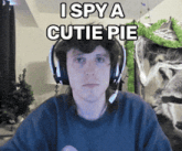 a man wearing headphones says " i spy a cutie pie " in front of a cat