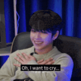 a young man is sitting in a chair with his hands on his chest and says oh , i want to cry .