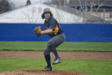 a baseball player wearing a bh hat is about to throw a pitch