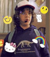 a boy wearing a brontosaurus sweatshirt with hello kitty and a rainbow on it