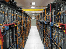 a row of servers are lined up in a room with lots of wires coming out of them