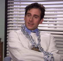a man wearing a chain around his neck is smiling