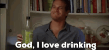 a man is holding a bottle of liquor and saying god , i love drinking .